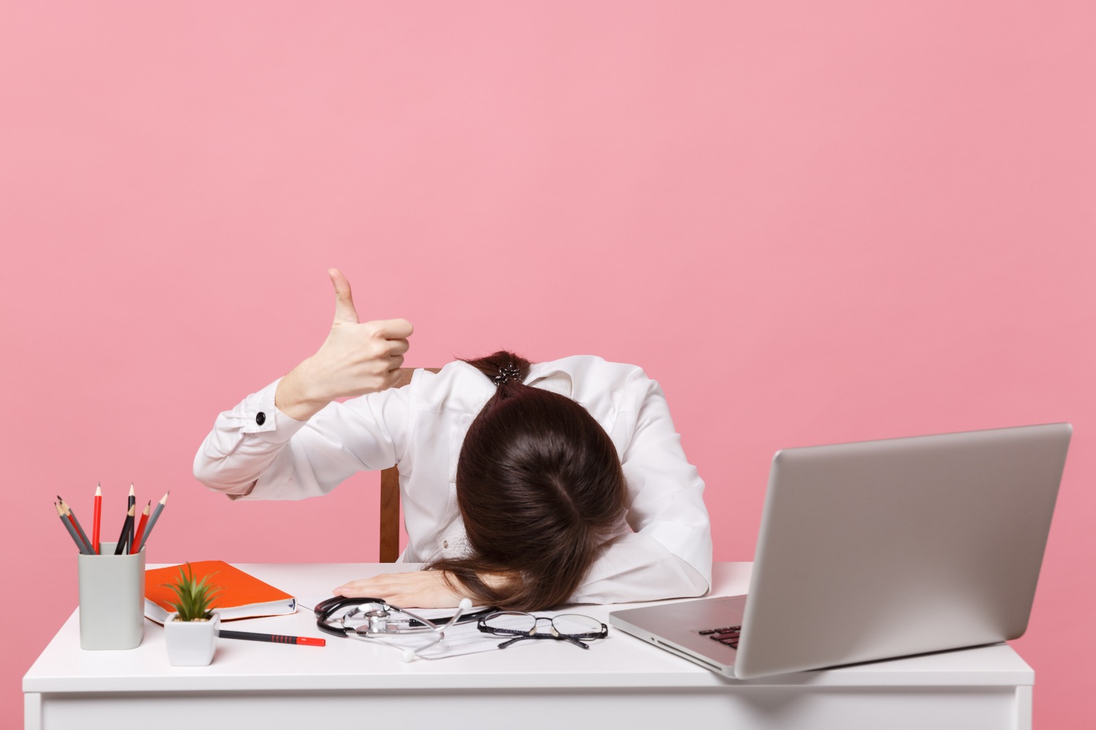 femme avachie sur son bureau pouce leve
